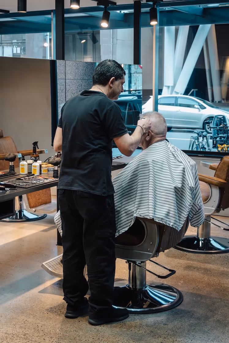 An interior shot of the Gentry & Blade barbershop with a focus on the lighting fixtures and styling chairs.