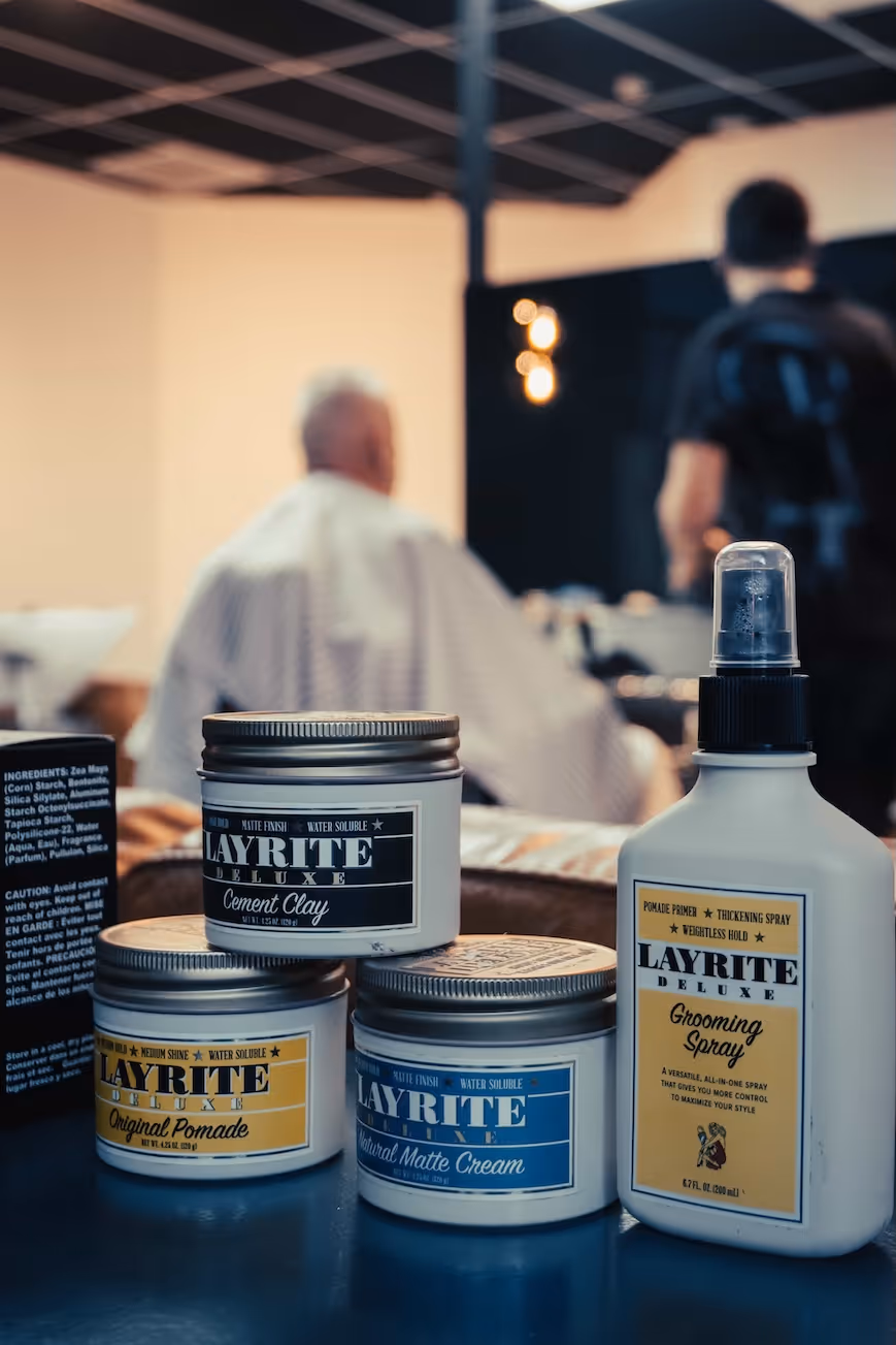 A barber preparing a hot towel for a shave or facial treatment on a client.
