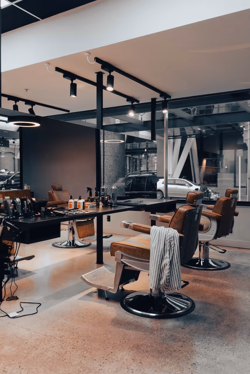 An interior shot of the barbershop, focusing on one of the main chairs and a large mirror.