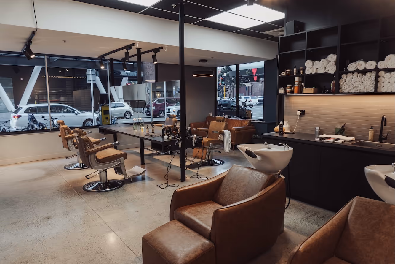 The interior of the barbershop, featuring the waiting area and multiple barber stations.